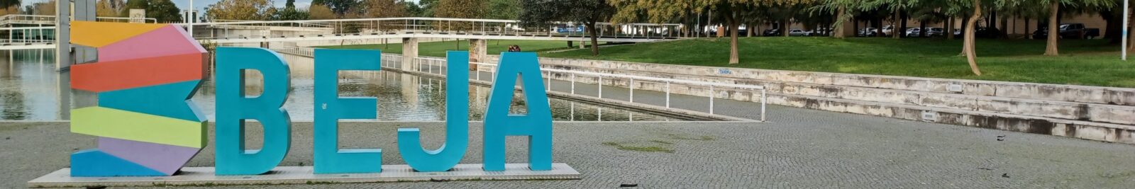 Here's an alt tag for the image: Beja city sign by the water.