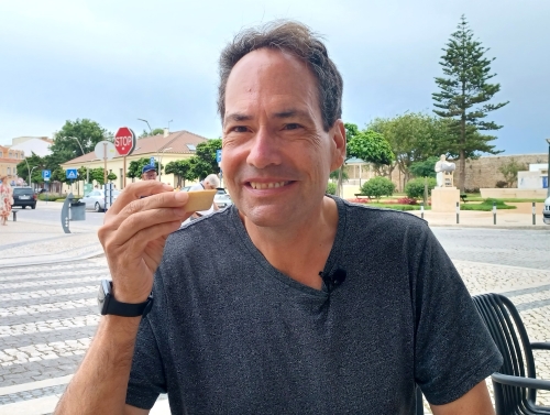 A man holding a piece of food in his hand.