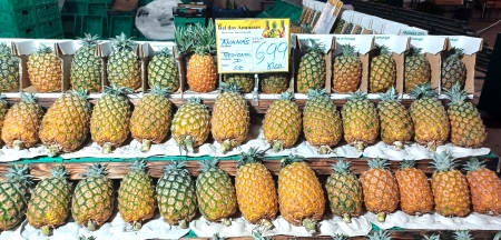 A display of pineapples for sale at an outdoor market.