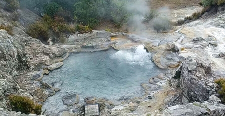 A hot spring with steam coming out of it.