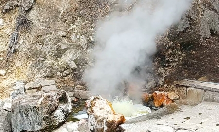 A large rock formation with steam coming out of it.