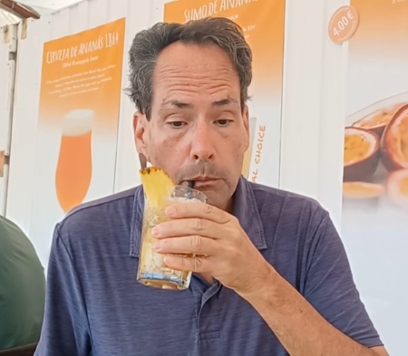 A man drinking from a glass of orange juice.