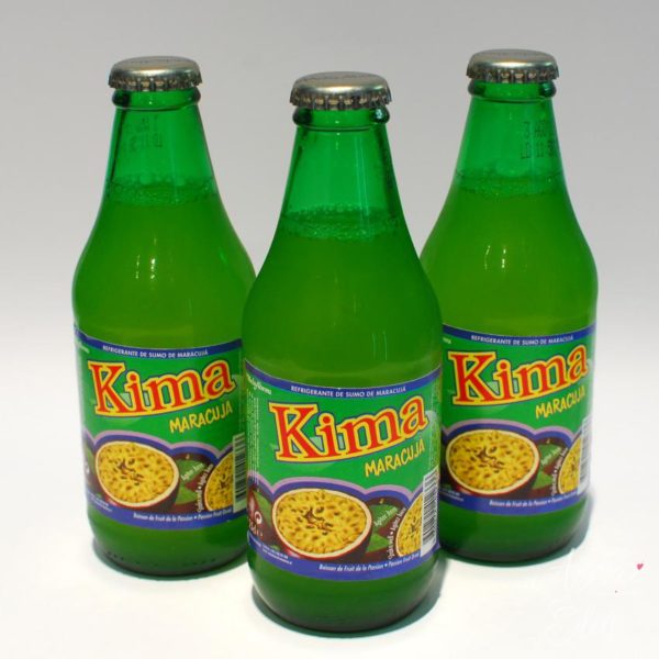 Three green bottles of soda sitting on top of a table.