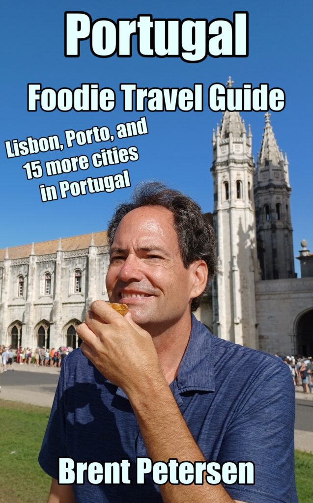 A man eating food in front of an old building.